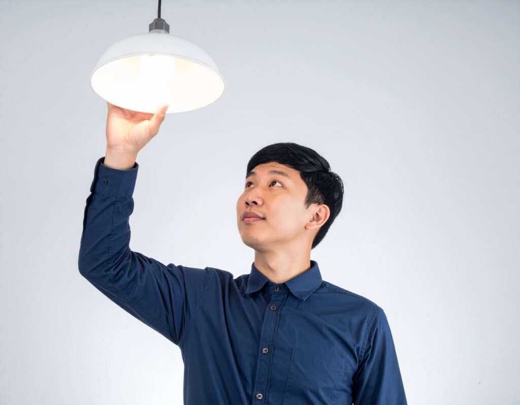 男子（亞洲人）抬頭觀察天花板燈管狀態 